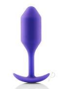 B-Vibe Snug Plug 2 Silicone Weighted Anal Plug Purple on a reflective surface, showcasing its design and color.