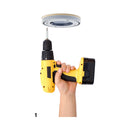 Hand holding a yellow drill ready to install Ouch Fully Adjustable Dance Pole Silver.