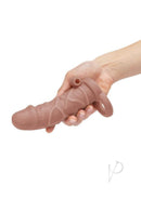 Size Up 1 Inch Vibrating Realistic Penis Extender Caramel held in hand for visual demonstration.