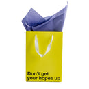 Don't Get Hopes Up Color Gift Bag Yellow with purple tissue paper for humorous gifting.