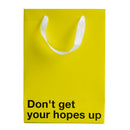 Don't Get Hopes Up Color Gift Bag Yellow features a bold message for gag gifts and holiday exchanges.