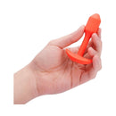 b-Vibe Vibrating Snug Plug 1 Weighted Silicone Anal Plug Orange held in hand for scale and demonstration.