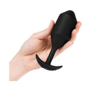 b-Vibe Vibrating Snug Plug 5 Weighted Anal Plug Black held in a hand showcasing its sleek design.