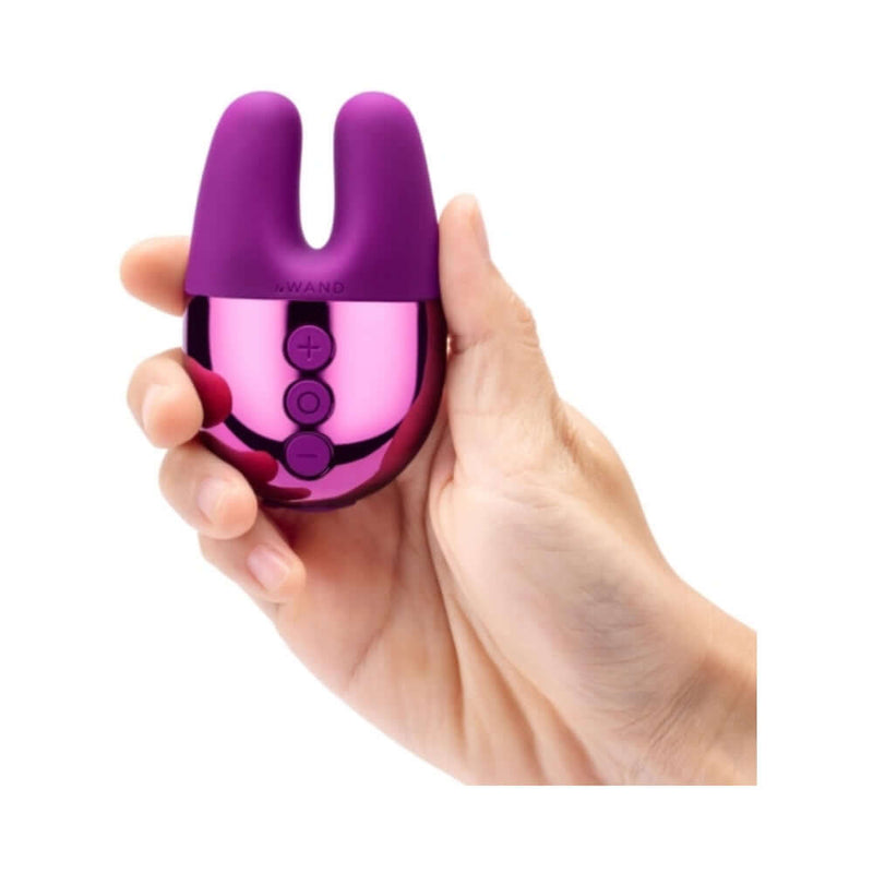 Le Wand Chrome Double Vibe Mini Vibrator Dark Cherry held in a hand, showcasing its palm-sized design and bunny ears.