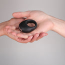 Je Joue Mio Rechargeable Vibrating Silicone Cock Ring Black held in hands for intimate couples experience.