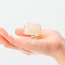 Iroha Petit Lily Disposable Clitoral Massager Clear held in a hand, showcasing its jelly-like texture.