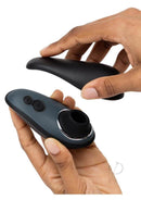 Womanizer Liberty from Fifty Shades of Grey X Desire Blooms Kit being held and opened by hands, showcasing sleek design and buttons.