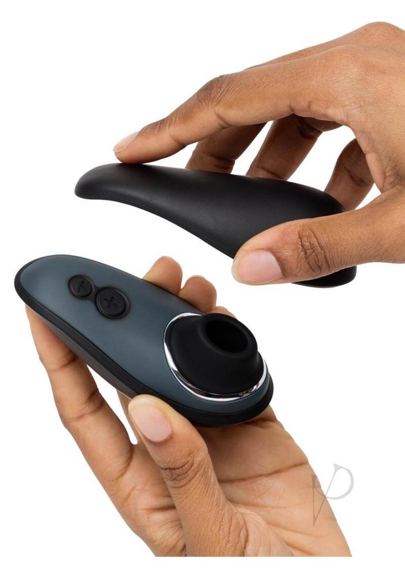 Womanizer Liberty from Fifty Shades of Grey X Desire Blooms Kit being held and opened by hands, showcasing sleek design and buttons.
