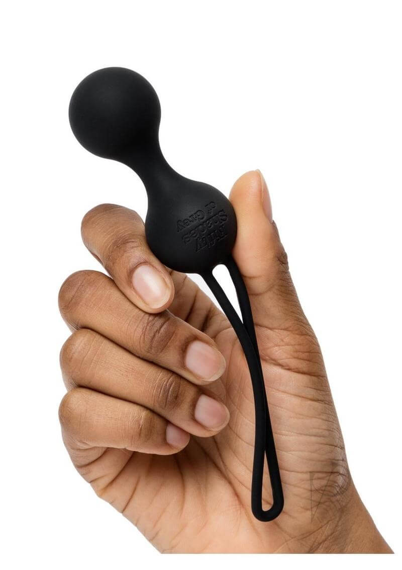 Hand holding black Kegel ball from Fifty Shades of Grey X Womanizer Desire Blooms Kit