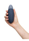 Womanizer Vibe Dark Blue clitoral vibrator with UltraWave technology held in hand, showcasing ergonomic design.