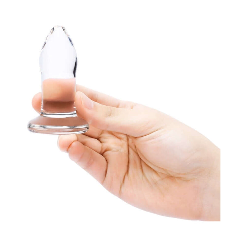 Person holding a b-Vibe 4 Piece Anal Dilators Glass Plug Set glass plug, showcasing its sleek design and body-safe material.