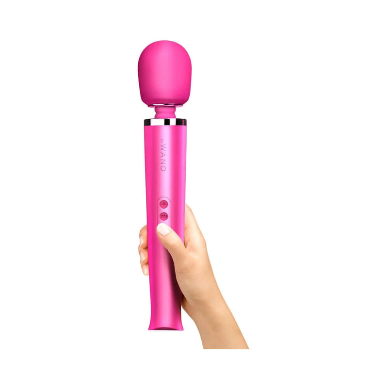Le Wand Rechargeable Vibrating Massager Magenta held by a hand, showcasing its sleek design and powerful features.