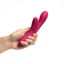 Je Joue Hera Rechargeable Silicone Rabbit Vibrator Fuchsia held in hand against a white background.