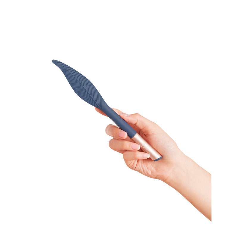 Deia The Feather Vibrating Tickler Silicone Blue held in hand, showcasing its sleek design and flexible texture.