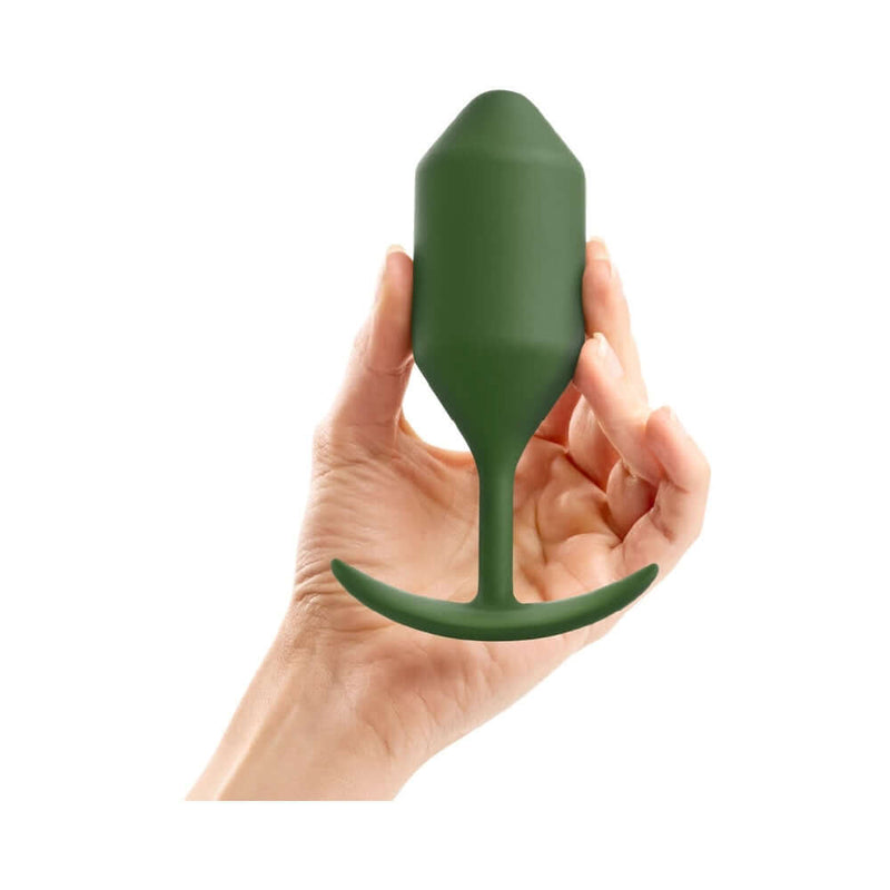 b-Vibe Snug Plug 4 Weighted Silicone Anal Plug Army held in hand, showcasing its ergonomic design and army green color.