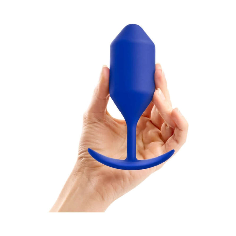 b-Vibe Snug Plug 4 Weighted Silicone Anal Plug Navy held in hand for perspective.