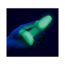 a hand holding a glowing b Vibe 10 Piece Asstronaut Glow in the Dark Butt Play Set toy in a dark setting