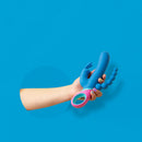 Hand holding the PMV20 Vice Double Vibrator Silicone Blue against a blue backdrop.