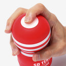 Tenga SD Original Vacuum Cup Masturbator Red being activated with a hand pressing the button on top.