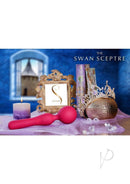The Swan Sceptre Silicone Dual End Wand Massager Magenta on a decorative table with candles and jewels.