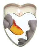 Earthly Body Suntouched Hemp Edible Candle Heart Tin Peach with a peach slice and a lit candle.