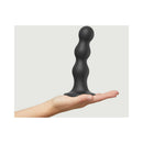 Strap-on-me Hybrid Silicone Dildo Plug Balls Black Large held in a hand, showcasing its design and features.