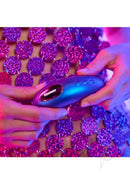Love To Love Dreamer Clitoral Vibrator Iridescent Night held in hands with colorful background.
