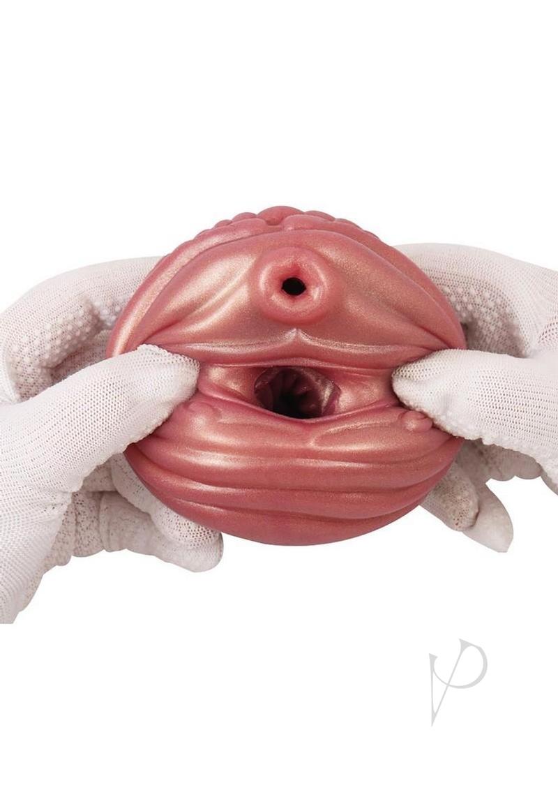 Monstar Cox Nebulux Stroker Fantasy Masturbator held in gloved hands, showcasing its unique design and texture.