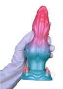 Monstar Cox FrostFang Cock Silicone Dildo in vibrant pink-to-blue gradient held in gloved hand.