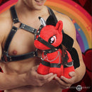 Master Series Bondage Pony Red plush held by a model in harness, showcasing vibrant red design and black accents.
