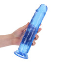 Realrock Crystal Clear Straight 10 Inch Dildo Blue held in hand, showcasing its sleek transparent blue design.