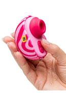 Romp Spin Travel Clitoral Stimulator Turn It Up Pink held in hand, compact design for on-the-go pleasure