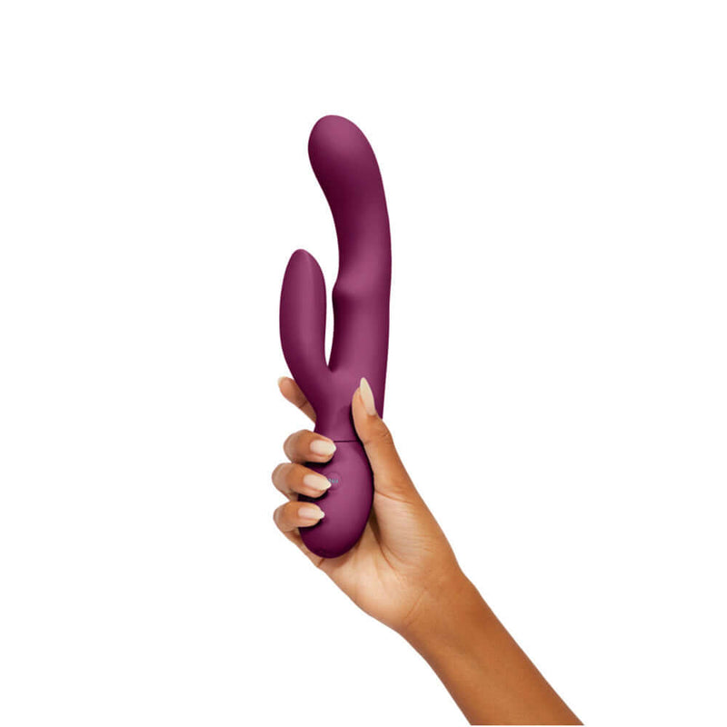 FemmeFunn Balai Swaying Motion Dual Stimulation Vibrator Fuchsia held in a hand against a white background.