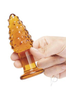 Glas Cornstar 4 Inch Glass Butt Plug Orange in hand, showcasing textured kernels and playful design for anal play.