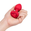b-Vibe Vibrating Heart Anal Plug Medium Large Red held in a hand showing its heart-shaped design and smooth finish.