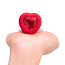 b-Vibe Vibrating Heart Anal Plug Medium Large Red held in hand with a jewel heart base.