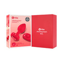 b-Vibe Vibrating Heart Anal Plug Medium Large Red packaging with plug and remote control in a stylish presentation.