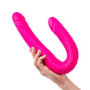 Together Duo Pink Vibrating Dildo held in hand, showcasing its flexible design and vibrant pink color.