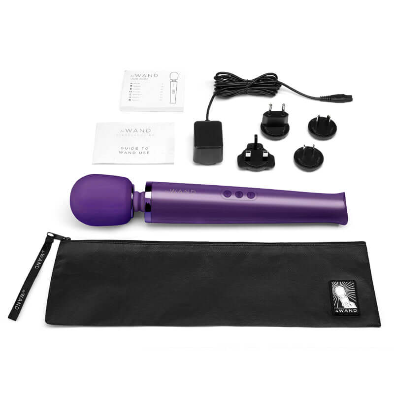 Le Wand Rechargeable Vibrating Massager Purple with accessories and charger on a white background.