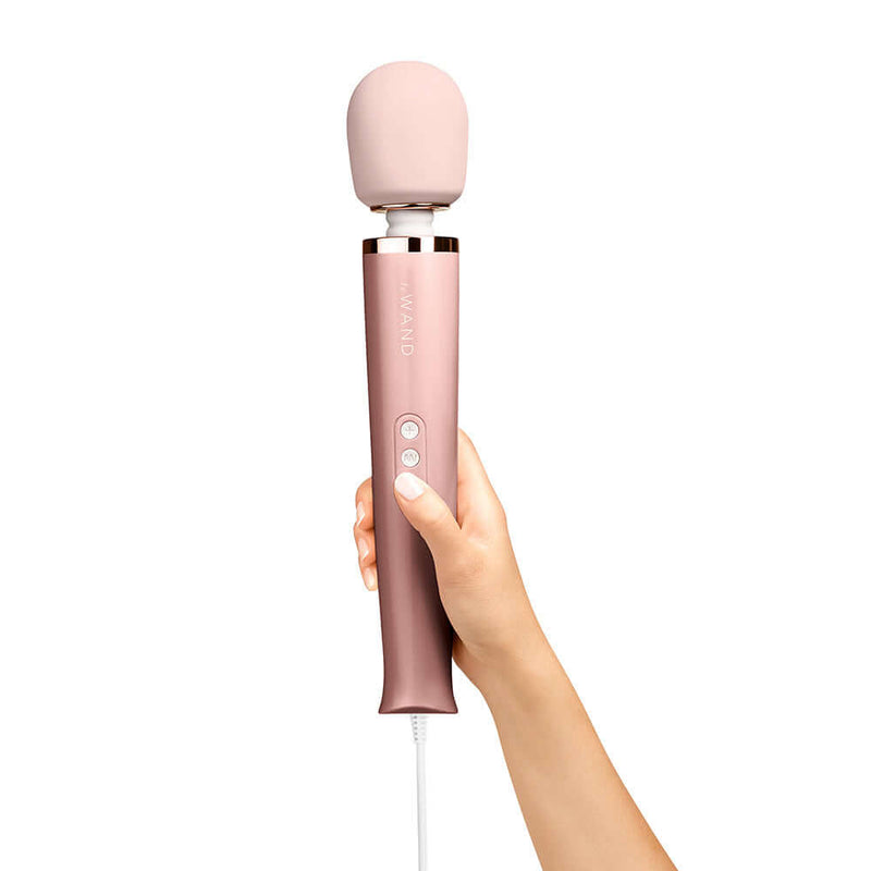 Le Wand Plug In Vibrating Massager Wand Rose Gold held in hand showcasing its design and features.
