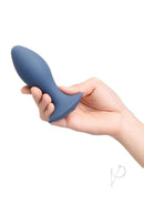 B-Vibe 4 Inch Rechargeable Silicone Vibing Plug Purple in a hand, showcasing its smooth silicone design.