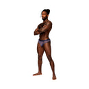 Male Power Sheer Prints Sheer Thong Spatter S/M modeled by a man standing confidently with arms crossed.
