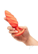 Hand holding B-Vibe Swirl Textured Silicone Plug Orange showcasing its textured design and vibrant color.
