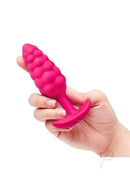 B-Vibe Bump Textured Silicone Plug Pink held in a hand, showcasing its playful bumpy texture and compact size.