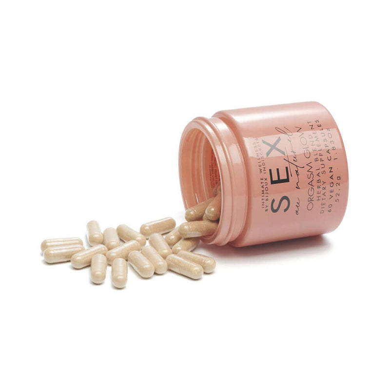 Bijoux Indiscrets Sex au Naturel Orgasm Glow Supplement 60 Pc capsules spilling from a pink container.