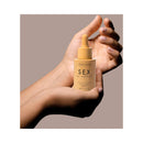 Bijoux Indiscrets Sex au Naturel Revitalizing Massage Drops 1 Oz held in a hand, showcasing its luxurious design.