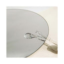 Bijoux Indiscrets Sex au Naturel Revitalizing Massage Drops 1 Oz on a reflective surface with applicator.