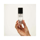 Bijoux Indiscrets Slow Sex Warming Massage Oil 1.69 Oz bottle held in hand against a light background.