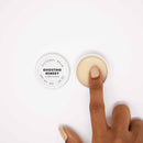 Bijoux Indiscrets Clitherapy Ghosting Remedy Clitoral Balm with a finger applying the balm.
