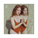 Bijoux Indiscrets Horoscope Kit Gemini: model poses by mirror in brown swimsuit, showcasing Gemini zodiac element.